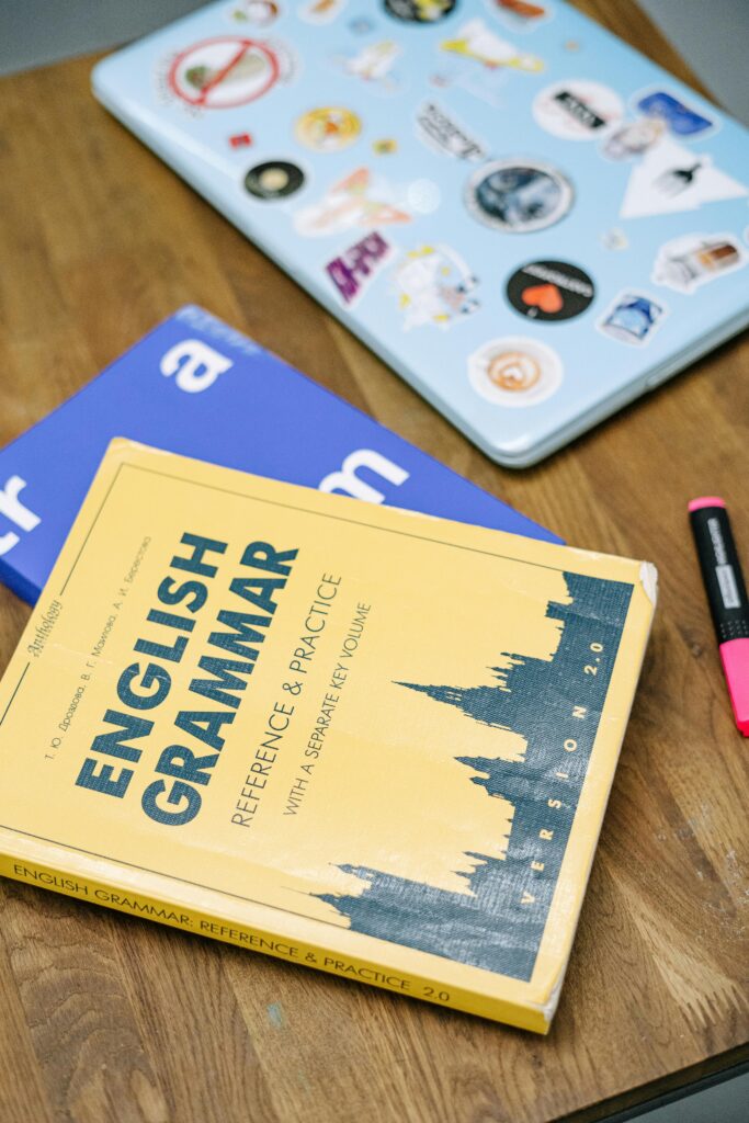 Libros y portátil sobre una mesa, ambientación de estudio de inglés
